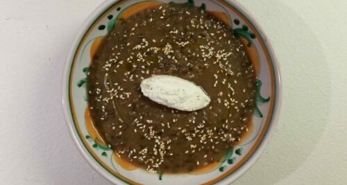 crema di lenticchie con verdure decorata con una knell di ricotta e semi di sesamo