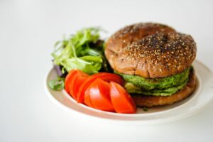 hamburger di lupini e spinaci impiattato con insalata e pomodori